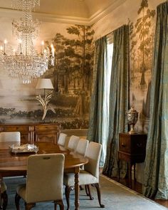 a dining room with a chandelier hanging from the ceiling and curtains on the windows