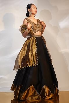 Black, gold attached cancan lehenga with cutdana, sequin embroidered border. Paired with sleeveless embroidered padded blouse and cutwork bordered dupatta. - Aza Fashions Evening Organza Lehenga With Cutdana, Gold Embroidered Party Dupatta, Gold Organza Sharara For Party Wear, Anarkali Tissue Silk Lehenga For Evening, Gold Organza Choli For Reception, Gold Organza Choli For Navratri, Party Gold Raw Silk Choli, Festive Gold Organza Choli, Gold Organza Choli With Cutdana