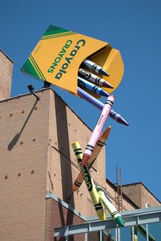 crayons are stuck to the side of a building with a sign on it