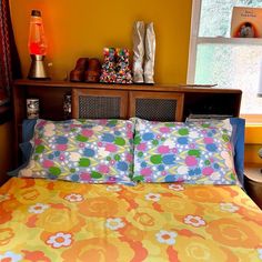 a bedroom with yellow walls and colorful bedding