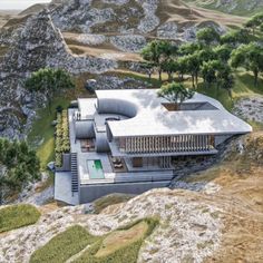 an aerial view of a house on top of a hill with trees and mountains in the background