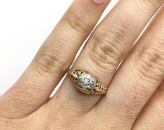 a woman's hand with a gold ring and diamond on the middle of her finger