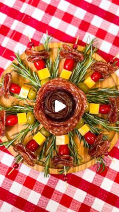 a wooden plate topped with lots of food on top of a red and white checkered table