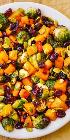 a white bowl filled with brussel sprouts and sweet potatoes