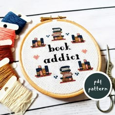 a cross stitch pattern with the words book addict on it next to scissors and thread