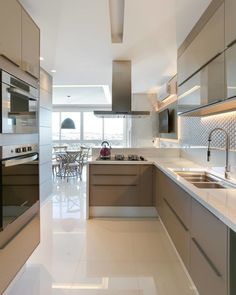 a modern kitchen with stainless steel appliances and white counter tops, along with an island