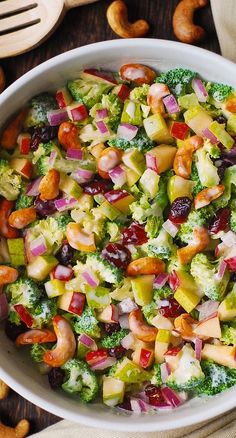 a white bowl filled with broccoli salad and nuts