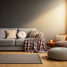 a living room scene with focus on the couch and throw blanket, pillows and floor cushions