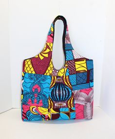 "This Bag is designed for both style and comfort. With its stylish look and practical storage, this bag can carry all sorts of things without any worries! Its spacious opening allows for easy access to your belongings. It is made with 100% cotton African Print fabric, fleece interface, and black canvas lining. MEASUREMENT: 16\" WIDTH X 16\" HEIGHT X 5 1/2\" DEPTH (WITHOUT HANDLE) FEATURES: 2 slide pockets 1 zipped pocket Magnetic snap closure See my other bags in this size here: https://www.etsy Trendy Tote Bag With Magnetic Closure, On-the-go Tote Shoulder Bag With Magnetic Closure, Travel Tote Shoulder Bag With Magnetic Closure, Versatile Multicolor Tote Bag, Multicolor Bag With Magnetic Closure For Daily Use, Multicolor Reversible Rectangular Shoulder Bag, Multicolor Shoulder Bag With Magnetic Closure For Everyday Use, Trendy Tote Satchel With Magnetic Closure, Reversible Square Bags