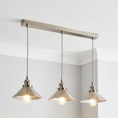 three lights hanging from a ceiling in a room