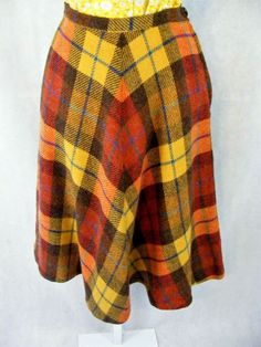 HERE WE HAVE THE PERFECT EXAMPLE OF EARLY 1970S FASHIONS  THE SKIRT IS WOOL PLAID IN BROWN, GOLD YELLOW , RED RUST AND BLUE , IT IS A FLARE SHAPE WITH A MEDIUM WAISTBAND AND SIDE METAL ZIPPER AND PLASTIC BUTTON THE SKIRT IS UNLINED   THE CONDITION IS NICE  THANK YOU FOR LOOKING AT MY LISTING . I AM ALWAYS HAPPY TO ANSWER QUESTIONS AND INQUIRIES Vintage Fall Pleated Skirt, Vintage Fall Skirt, Vintage Flared Skirt For Fall, Vintage Pleated Skirt For Fall, Vintage Flared Skirt Bottoms For Fall, Vintage Knee-length Brown Skirt, Vintage Brown Knee-length Skirt, Brown Full Skirt For Fall, Vintage Lined Skirt For Fall