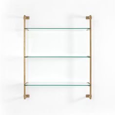 three glass shelves with brass brackets on each shelf, one is empty and the other two are closed