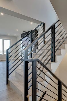 a white staircase with black handrails in a house