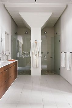 a bathroom with a sink, mirror and bathrobe