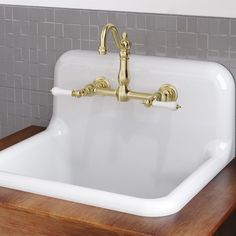 a white sink sitting on top of a wooden counter next to a tile backsplash