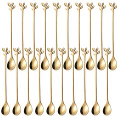 gold spoons with sprouts and leaves are lined up in rows on a white background