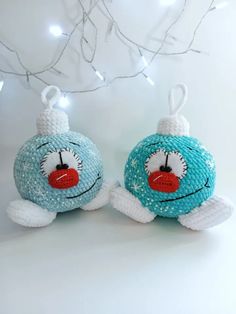 two blue and white knitted ornaments hanging from a tree