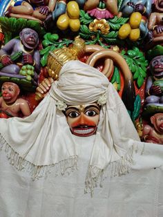 an elaborately decorated mask is displayed in front of many other colorful figures on display