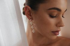 a woman wearing earrings looking out the window