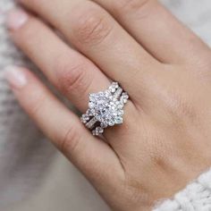 a woman's hand with a diamond ring on top of her finger and an engagement band