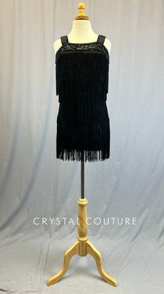 Black lycra mini dress with 4 rows of 9 inch Black fringe. Neckline of dress is accented with Black Zsa Zsa sequin fabric for added shimmer. Straps are 2 inches wide to easily hide built in adjustable bra straps. Dress includes built in Black lycra leotard. *Accessories include Black sequin headband with attached White feather and large rhinestone brooch, and white pearl necklace. **Costume in image is an AXS, Photographed on an AXS/AS Mannequin with Measurements of: Bust 30", Waist 25", Hip 31" Trio Costumes, Sequin Jewelry, Costumes Couture, Adjustable Bra, Sequin Appliques, White Pearl Necklace, Group Costumes, Tutu Costumes, Black Fringe