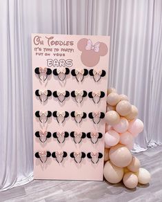 a pink and black mickey mouse themed birthday party with balloon garlands on the floor