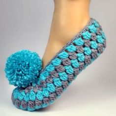 there is a crocheted slipper with a pom - pom on it