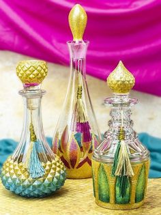 three colorful glass bottles sitting on top of a table