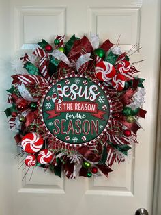 a christmas wreath on the front door with candy canes and saying jesus is the reason