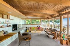 a living room filled with lots of furniture next to a large window covered in wood