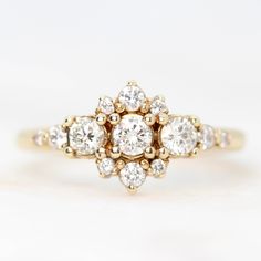 an antique diamond cluster ring in yellow gold with diamonds on the band and center stone