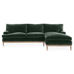 a green velvet sectional sofa with wooden legs