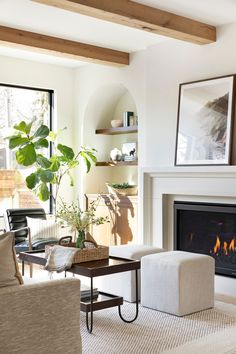 a living room filled with furniture and a fire place in front of a large window