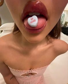 a woman sticking out her tongue with a button on it