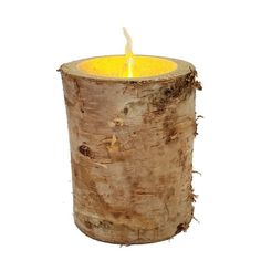 a candle that is sitting on top of a tree stump in front of a white background