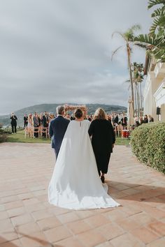 a bride and groom walking down the aisle