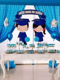 a table topped with blue desserts and balloons