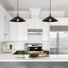 two lights hanging over a kitchen island