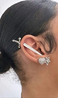 a woman with ear piercings on her ears wearing an ear cuff and nose ring