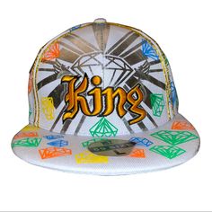 a white hat with the word king written in yellow and orange letters on it's side