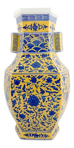 a blue and yellow vase sitting on top of a white table