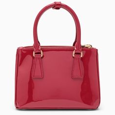 Mini Galleria handbag from Prada in cherry-coloured patent leather, featuring two top handles, snap fasteners on the sides, two zipped compartments, an interior zipped pocket, an adjustable and removable shoulder strap, a removable logoed key ring and gold-coloured metal hardware. Width 24 cm x Height 18 cm x Depth 11 cm Adjustable shoulder strap length min 116 cm - max 126 cm Handle drop: 10 cm Size Type: INTMaterial: LeatherSKU: 1BA906EOM069/O_PRADA-F0E06_100 Our Products Are 100% Genuine. In Classic Red Bag With Glossy Finish, Elegant Red Bag With Glossy Finish, Red Leather Bags With Glossy Finish, Glossy Patent Leather Top Handle Bag, Formal Red Bag With Glossy Finish, Formal Red Bags With Glossy Finish, Red Glossy Formal Bags, Classic Patent Leather Bag With Glossy Finish, Top Handle Shoulder Bag With Glossy Finish For Shopping