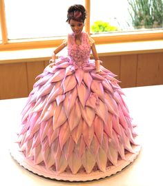 a cake made to look like a woman in a ball gown with feathers on it