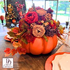 an orange pumpkin decorated with flowers and leaves