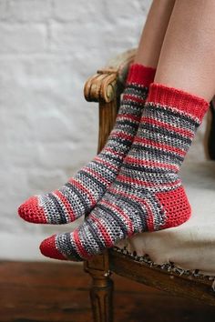 a woman sitting in a chair with her legs crossed wearing striped socks and high heels