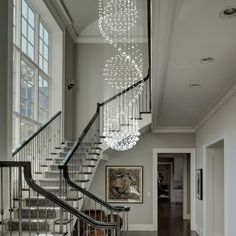 a staircase with chandelier hanging from the ceiling