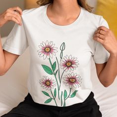 Brighten your wardrobe with this Charming Daisy Bouquet T-Shirt. Featuring a beautifully illustrated cluster of daisies with vibrant green leaves, this design brings a touch of nature's elegance to your outfit. Perfect for casual wear, this t-shirt combines comfort and style with its high-quality fabric and eye-catching floral artwork. Ideal for nature lovers and those who appreciate delicate, botanical designs. ✿The unisex soft-style t-shirt puts a new spin on casual comfort. Made from very soft materials, this tee is 100% cotton for solid colors. Heather colors and sports grey include polyester. The shoulders have twill tape for improved durability. There are no side seams. The collar is made with ribbed knitting to prevent curling damage. ✿Made with 100% ring-spun cotton, a lightweight White Daisy Print T-shirt For Summer, White Floral Print T-shirt Relaxed Fit, White Floral Print Relaxed Fit T-shirt, Green Floral Embroidery T-shirt For Spring, Spring Green T-shirt With Floral Embroidery, Green T-shirt With Floral Embroidery For Spring, Green Floral Embroidered T-shirt For Spring, White Daisy Print Tops For Spring, Spring Botanical T-shirt With Floral Design