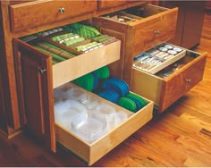 an open drawer in a kitchen filled with dishes