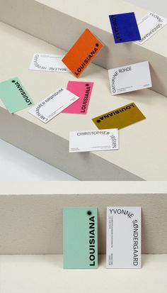 several different types of business cards hanging on a white wall, with the same color as each one