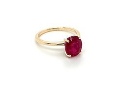 a gold ring with a red stone on it